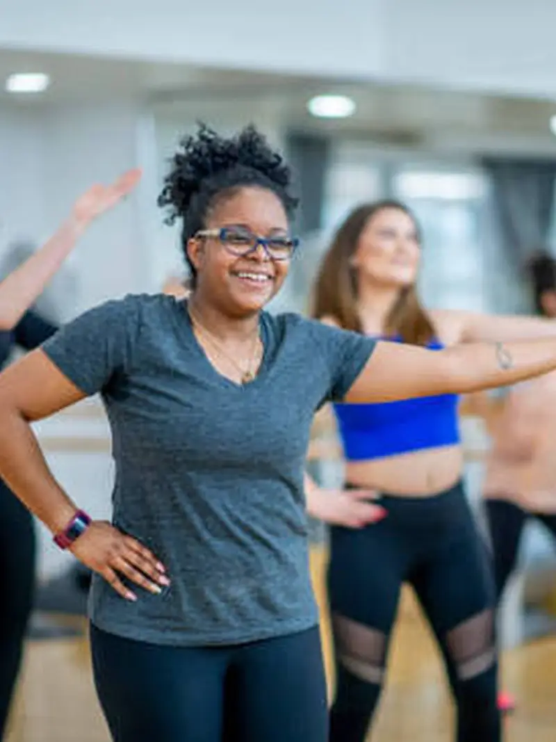 Aluna sorrindo durante aula de fitdance em grupo na Hulk Power